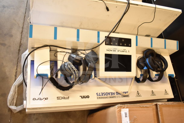 Store display with Turtle Beach gaming headphones and small monitor, featuring headset holders and multiple connections.