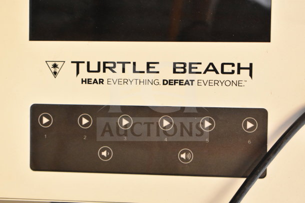 Turtle Beach store display with headphones, featuring a monitor and control panel. "Hear Everything. Defeat Everyone" slogan visible.