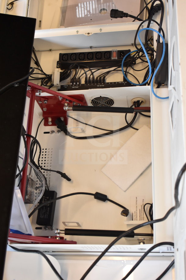 Store display interior with organized cables, power supply, and display components. Includes monitor and headphone ports.