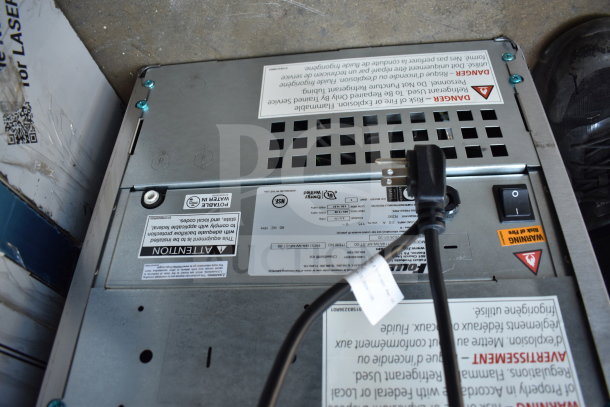 Follett 15 Series ice maker, model 15CI114A-IW-NF-ST-00, air-cooled, 15 lb bin, 100 lb capacity, 115V, 1 phase. Warning labels visible.