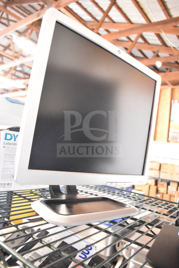 Four monitors including Dell and HP, metal stand, visible controls on bottom, minor wear, ideal for bidding value.