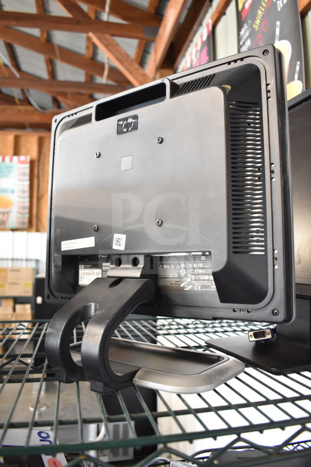Four computer monitors, including Dell and HP models, in good condition on display. HP logo visible on back.