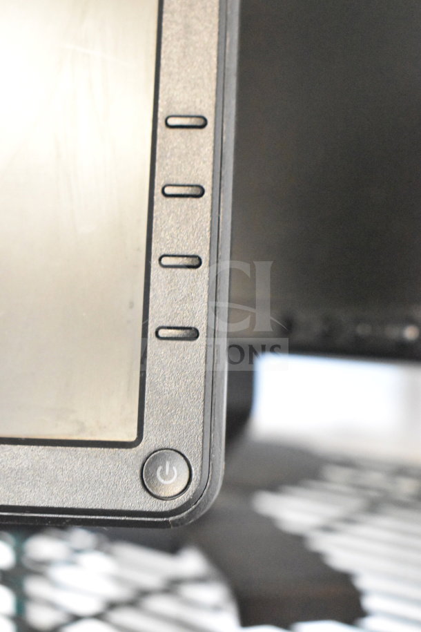 Four monitors, including Dell and HP, with visible control buttons and power symbol. Good condition; auction item.