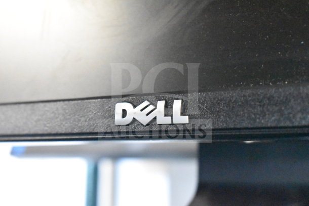 Four monitors including Dell and HP, featuring visible Dell logo. Condition unknown. Auction lot offers four monitors.