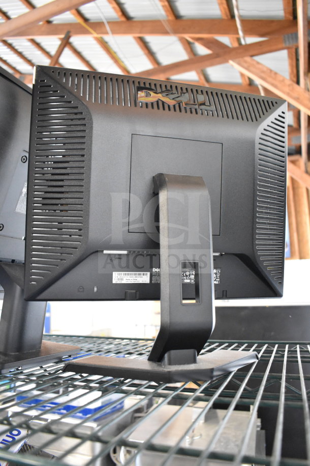 Four monitors including a Dell with adjustable stand, visible labels and ports, good condition.