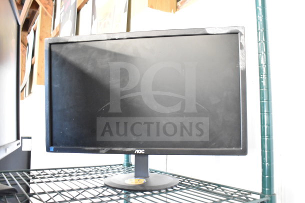 Four assorted monitors including Dell and HP, displayed on a metal shelf. Some wear visible, ideal for multi-screen setups.