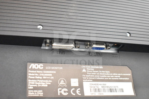 Close-up of AOC monitor model E2280SWDN, featuring DVI and D-SUB ports, label with serial number B80HBGA012075, and warning text.