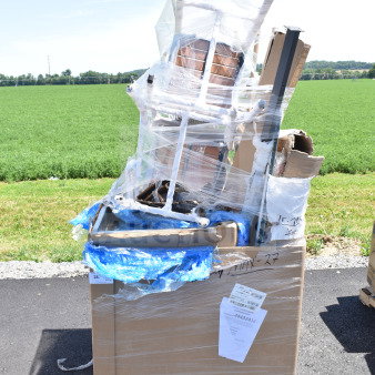 Pallet of 11 new scratch and dent items, including chairs, wrapped in plastic and cardboard. Tags with item details attached.