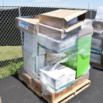 Pallet with various boxed items, including napkins, containers, wrapped in plastic. Marked with auction lot number 298.