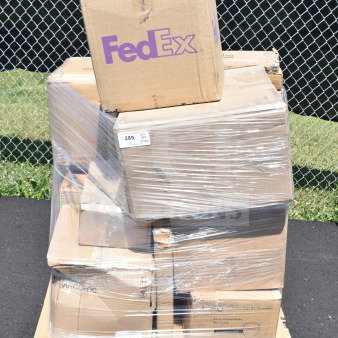 Pallet of shrink-wrapped boxes including tea cups, glasses, milk crates. Boxes marked FedEx and Arcoroc. Scratch and dent condition.