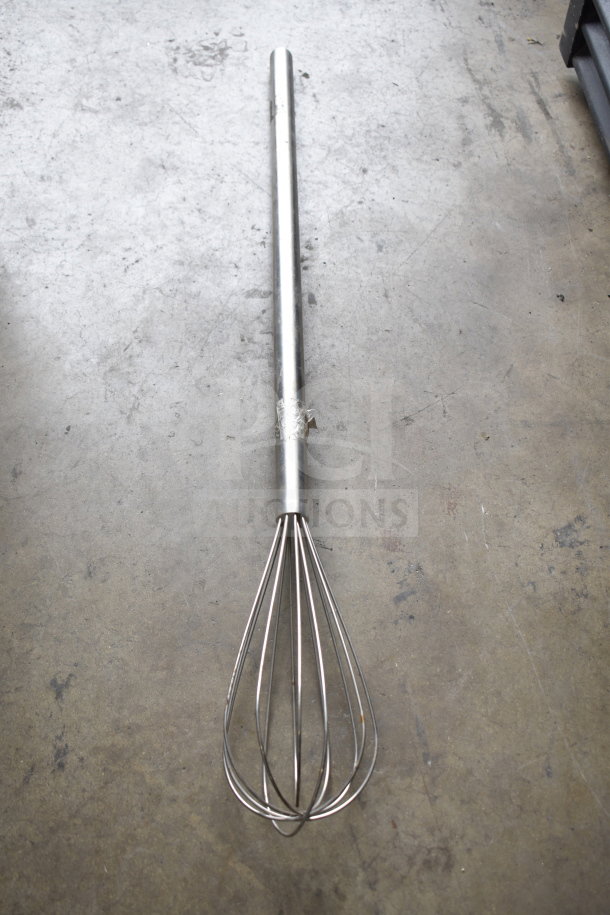 Steel whisk with long handle on concrete floor, part of a 5-item auction set including blades, paddle mixer attachment, and vent cover.