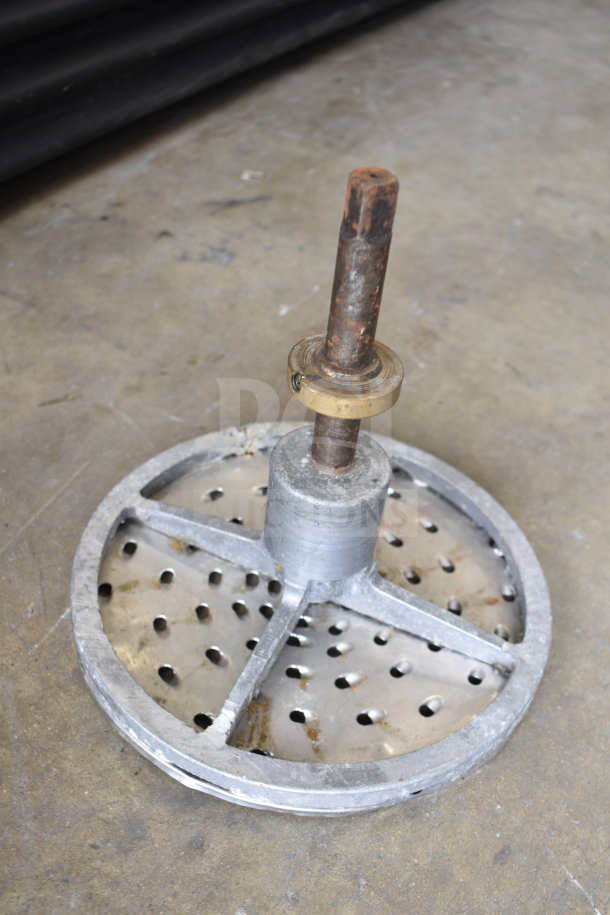 Metal paddle attachment for mixer with rusted rod. Circular base with perforations. Weathered condition.