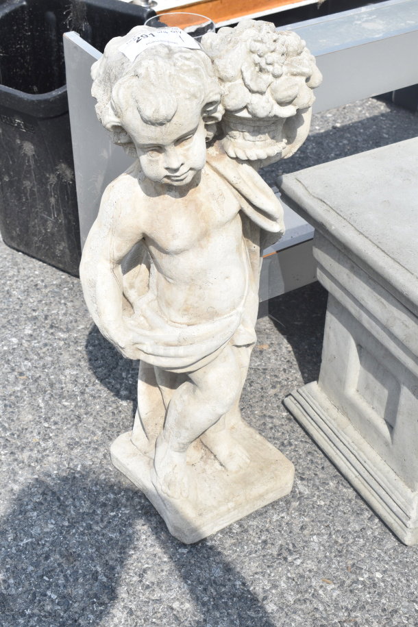 Stone statue of a cherub carrying a floral basket, showing slight weathering. Measures approximately 2 feet tall.
