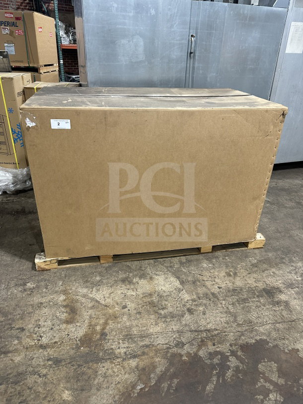 Cardboard box containing new Continental SW602N24M/D00 sandwich prep table, model SN: 162A5375, on pallet in warehouse.