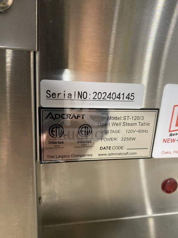 Alt text: Adcraft Stainless Steel Electric 3-Pan Steam Table, Model ST-120/3, Serial No. 202404145, 120V, 2250W, with undershelf storage.