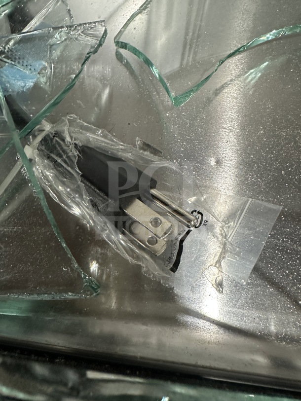 Broken glass from Hoshizaki refrigerated display case, model HNC-210BA-L-SLH. Visible plug; item labeled "scratch n dent."