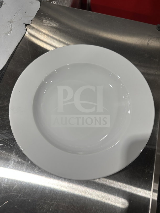 White ceramic dinner plate on a stainless steel surface, in excellent condition, with a glossy finish.