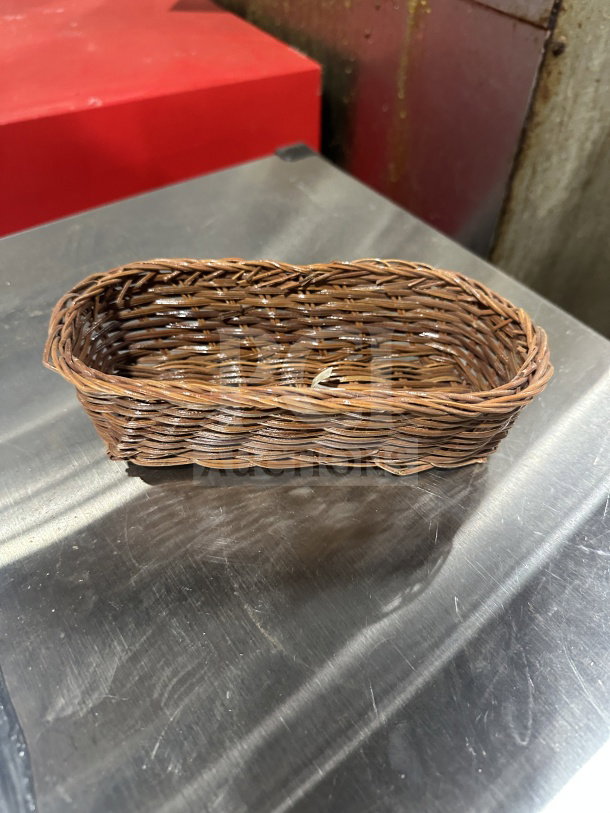 Browne woven polypropylene basket for food display, brand new, 48 pieces per box, on metal surface.