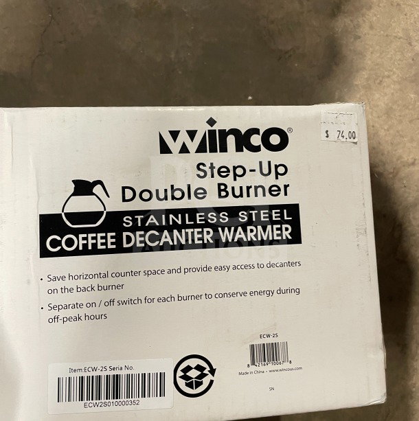 Brand new Winco ECW-25 stainless steel double coffee decanter warmer, in box, model details and price tag visible.