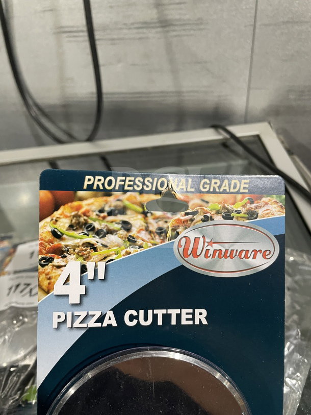 Winco 4" commercial stainless steel pizza cutter, brand new, with black plastic handle, model PPC-4. Packaging reads "Professional Grade."
