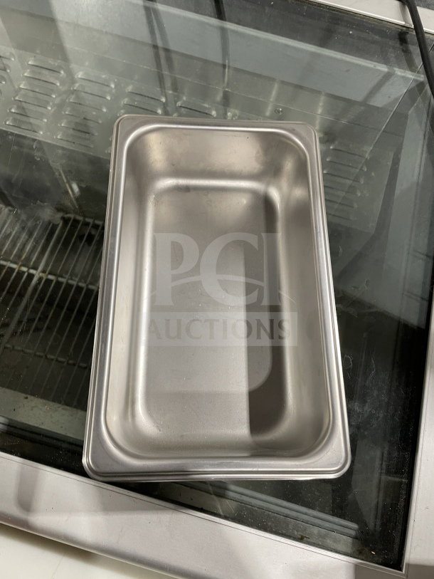 Brand new Thunder Group stainless steel steam table pan, model STPA3142, displayed on glass table.