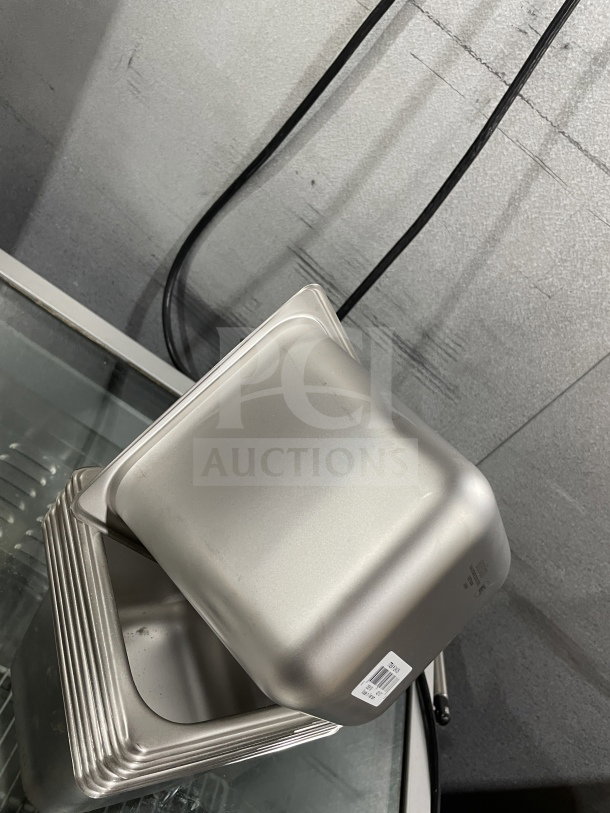 Brand new Amko commercial stainless steel steam table pan, model STPA3142. Stack of pans, visible label with model info.