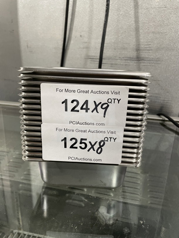 Brand new Amko stainless steel half-size steam table pans, Model 24602, stack of multiple units with auction labels.