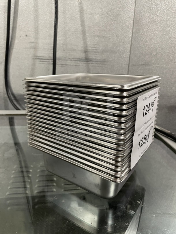 Brand new Amko stainless steel half-size steam table pans, model 24602, stacked with visible inventory labels.