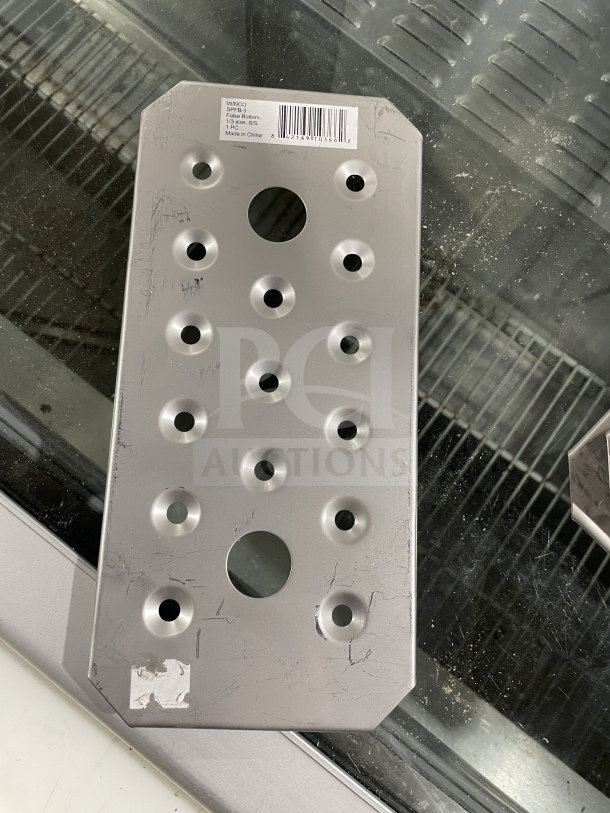 Winco SPFB-3 stainless steel third-size false bottom, new. Features perforations, with label showing model and SN: 842169103662.