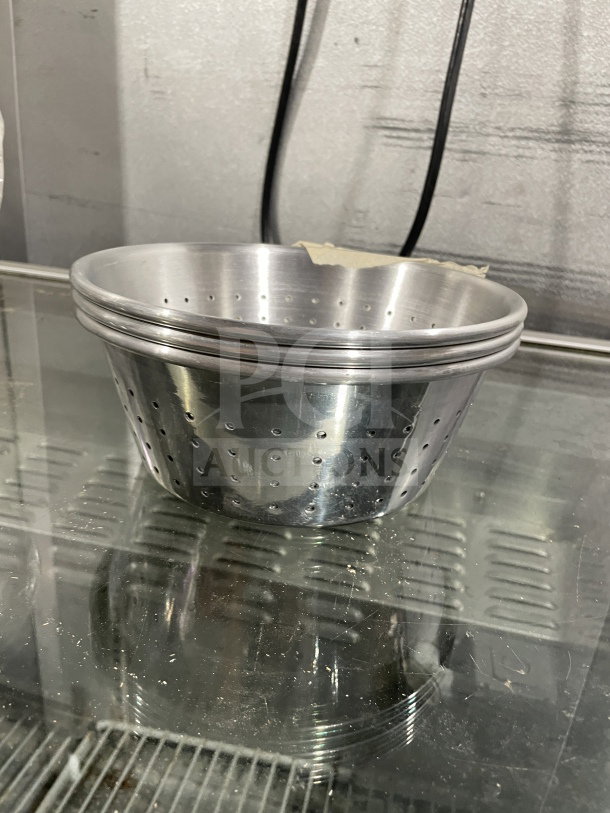 Brand new commercial 1/3" aluminum colander in pristine condition, showing holes and smooth finish.