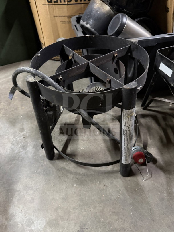 Industrial propane burner, model TF2038101-MM-01. Black metal frame, visible wear. Includes control knob and safety labels.