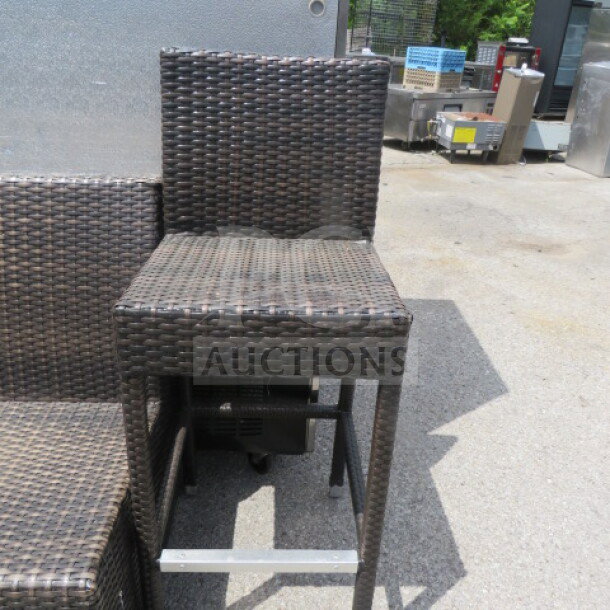 Bar height wicker patio chair with dark brown weave. Modern design, sturdy build. Excellent condition, ideal for outdoor use.