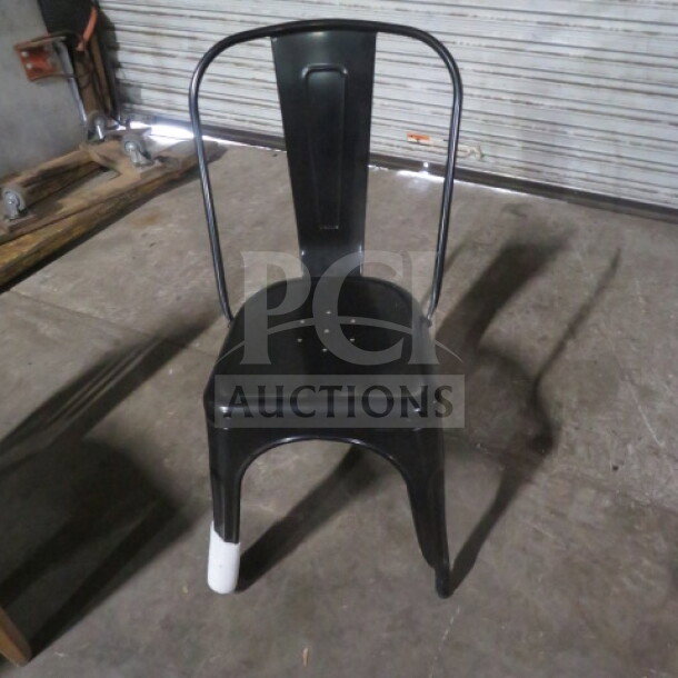 New industrial black metal chair with arched backrest, perforated seat, and protective leg cover. Model 2XBID.