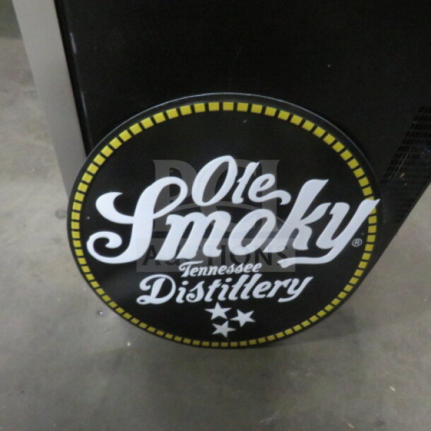 Ole Smoky 17.5" round tin sign, black with yellow and white logo, "Ole Smoky Tennessee Distillery," in good condition.