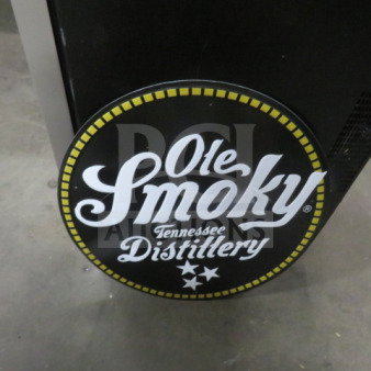 Ole Smoky 17.5" round tin sign, black with yellow and white logo, "Ole Smoky Tennessee Distillery," in good condition.