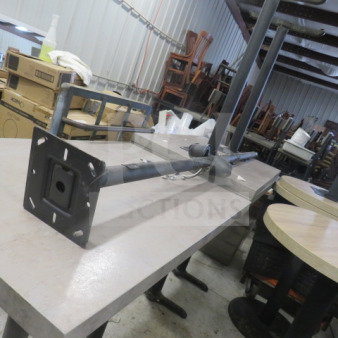 Black metal TV mount pole, wall-mount style with adjustable arm. Moderate wear, visible in storage setting.