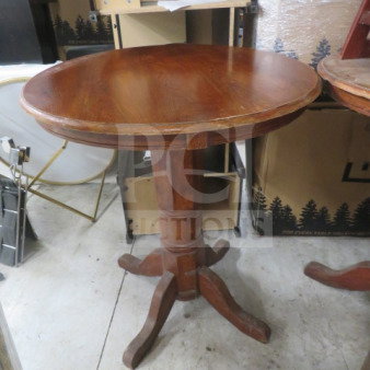One wooden bar height table, 36x42 inches, with a round top and sturdy wooden base. Smooth finish, in good condition.