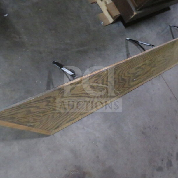 Wooden shelf with metal brackets, 88x9.5 inches, oak finish, good condition, visible wood grain pattern.