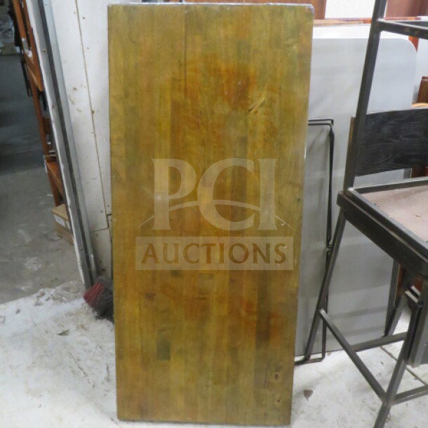 54x24 wooden table top with a natural finish. Features slight wear, showcasing wood grain patterns. Ideal for furniture projects.