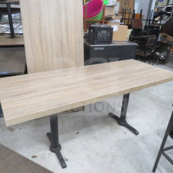 Brown wooden tabletop on dual black pedestal bases, 72x30x30 inches, in good condition.