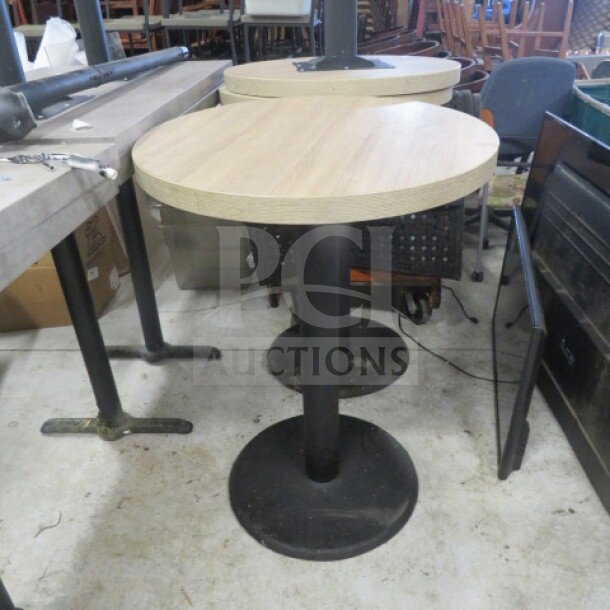 Round brown table top on a black bar height pedestal base, 30x42 inches, in good condition, suitable for dining or bar use.