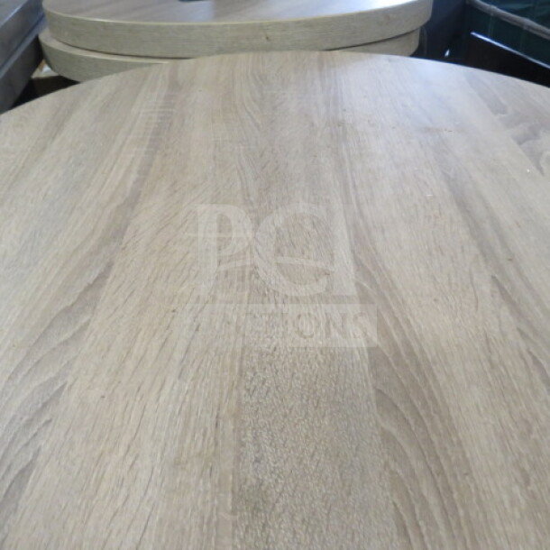 One round brown table top on a bar height pedestal base, 30x42 inches, wood grain finish, excellent condition.