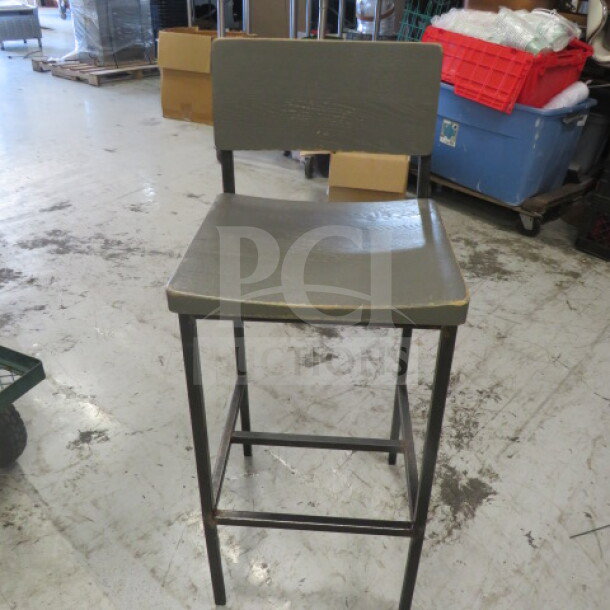 Black metal bar height chair with gray wooden seat and back, 2XBID. Minor wear visible on edges, sturdy frame.