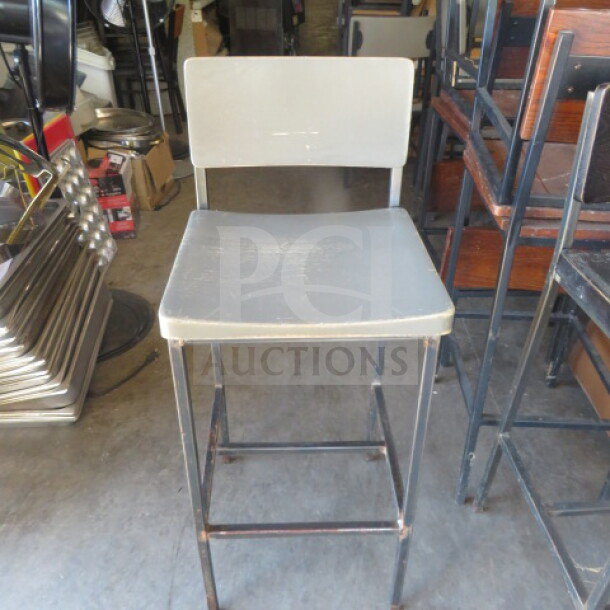 Black metal bar height chair with gray wooden seat and back. Features sturdy construction. Some wear visible. Marked 2XBID.