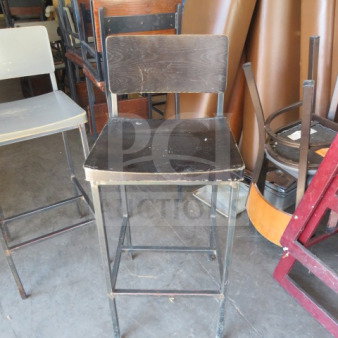 Black metal bar height chair with a black wooden seat and back. Slightly worn condition. Distinctive industrial style.