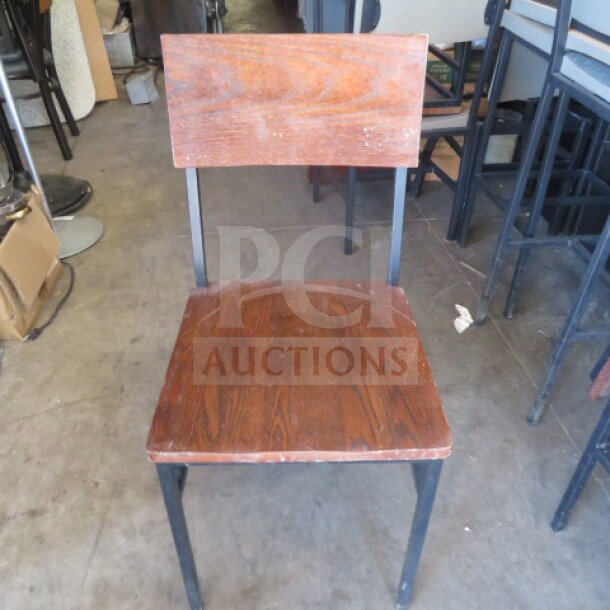 Black metal chair with brown wooden seat and back, new condition, model 2XBID.