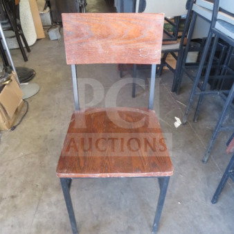 Black metal chair with brown wooden seat and back. Features sturdy frame, natural wood grain, and visible wear. Model 2XBID.