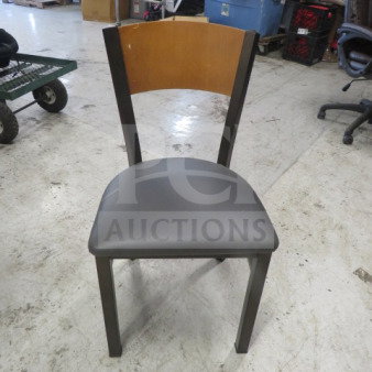 Black metal chair with a gray cushioned seat, wooden backrest, and sturdy frame. Model: 2XBID. Good condition.