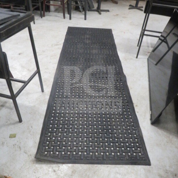 Black rubber fatigue mat, 107x33.5 inches, used condition, featuring a grid pattern. Ideal for workplace comfort.