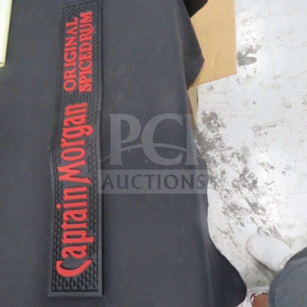 Captain Morgan bar mat with red lettering on black background, featuring "Original Spiced Rum" text. Appears in good condition.